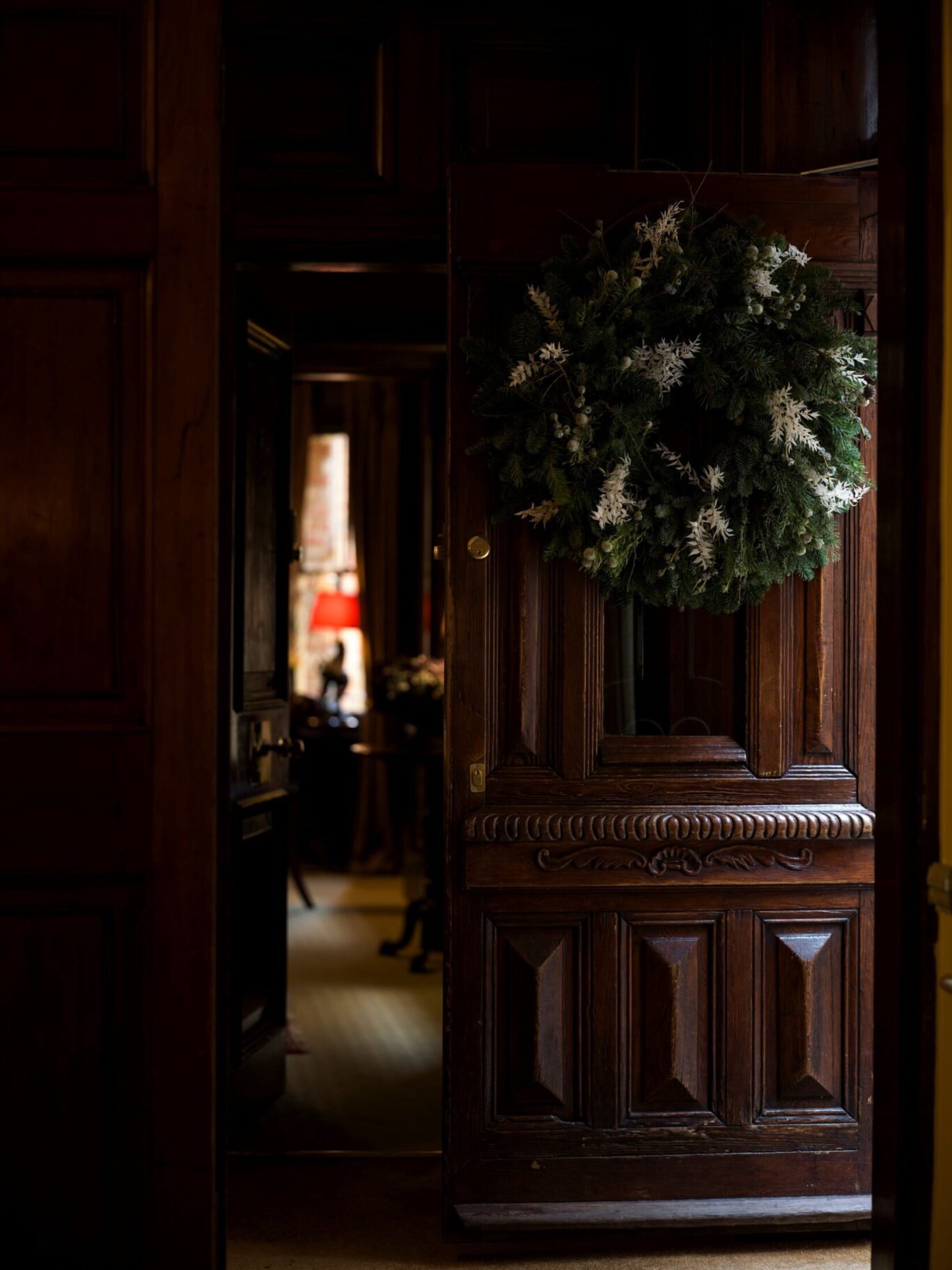 Wood-panelled doorway at The Rookery in Clerkenwell decorated with a large evergreen Christmas wreath.
